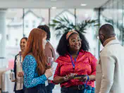 Three office workers talk at an office mixer