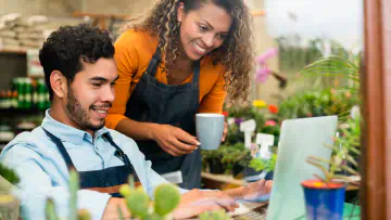 Two florists use a computer