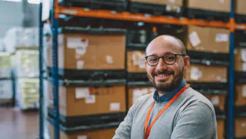 Man stands in front of shelves full of packages