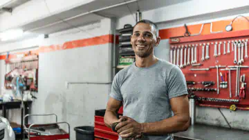 Man stands in front of wall of tools