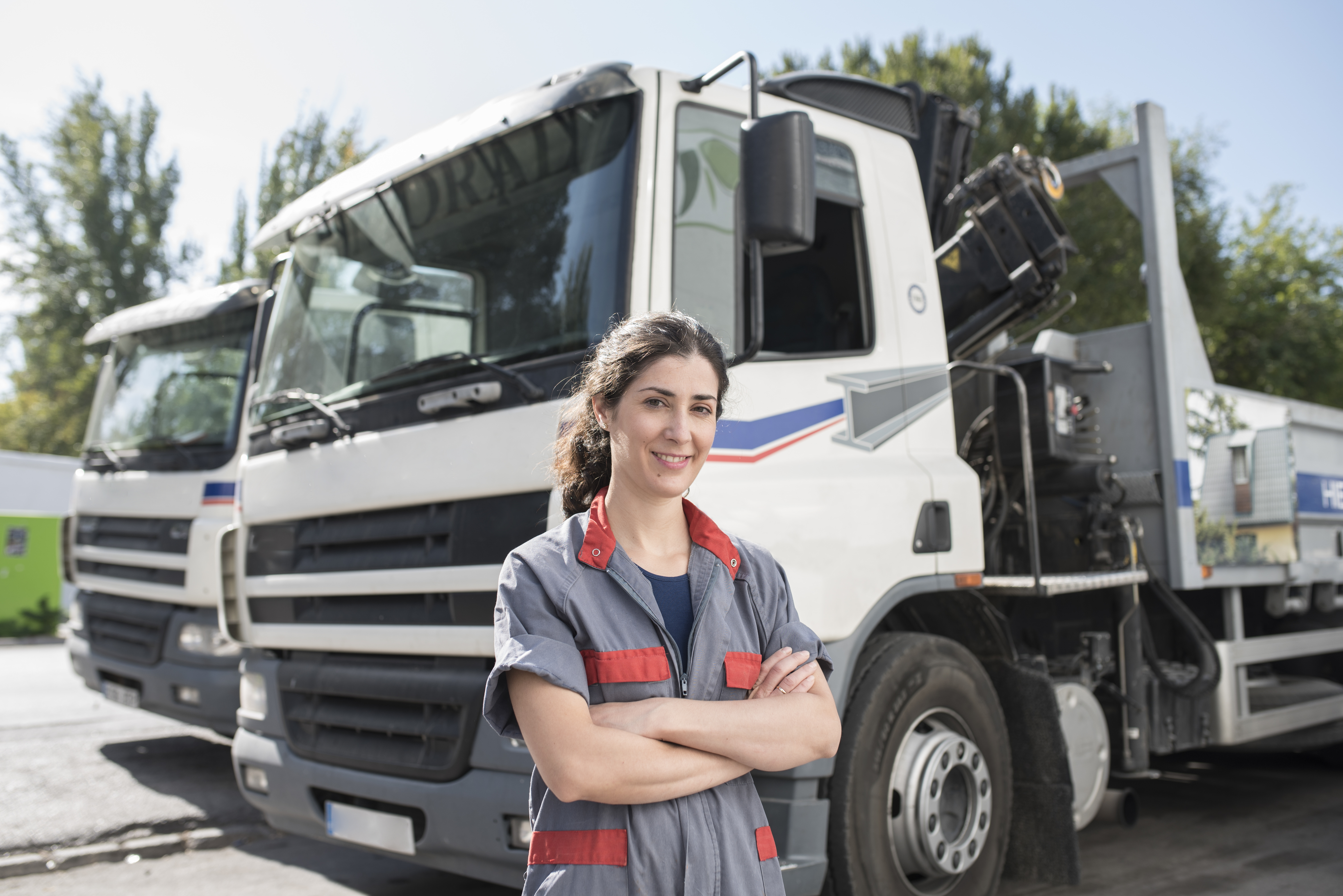 Truck driver stands in front of their vehicle